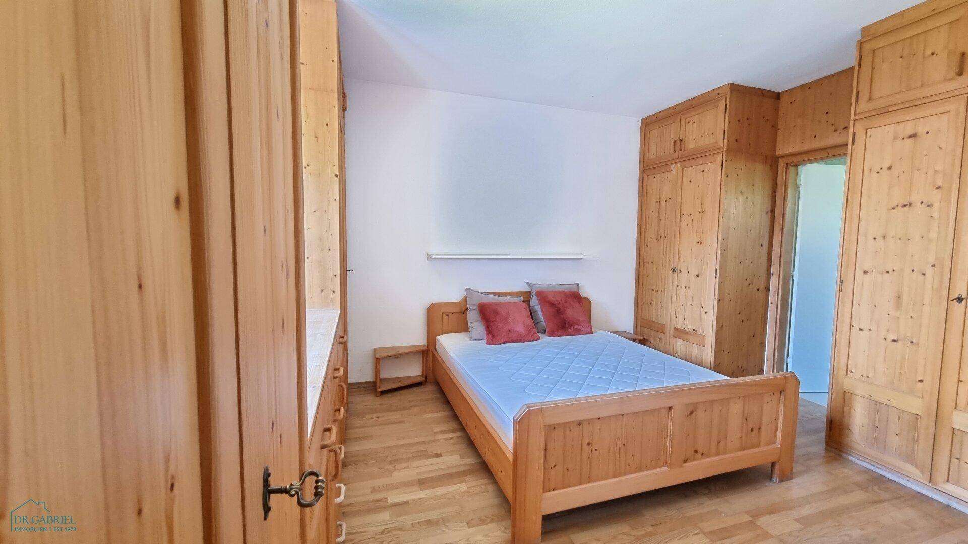 Schlafzimmer mit hellen Holzmöbeln, Holzboden und viel Stauraum durch Einbauschränke.