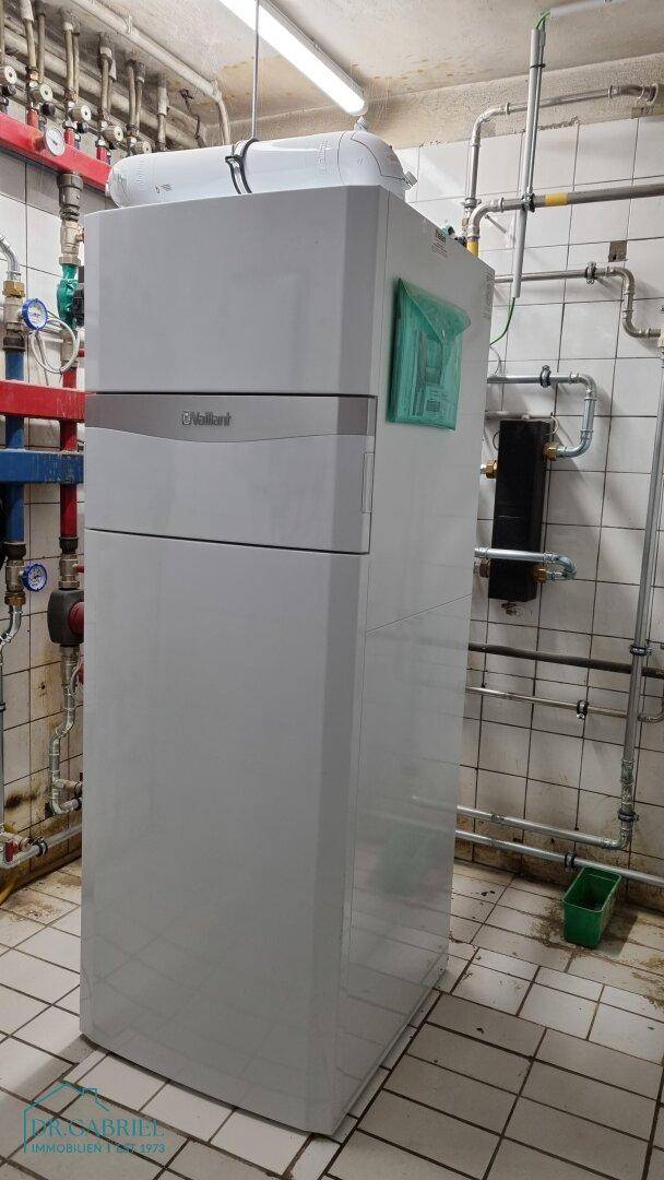 Heizungsraum mit moderner Vaillant-Heizanlage und sichtbaren Rohrleitungen an den gefliesten Wänden.