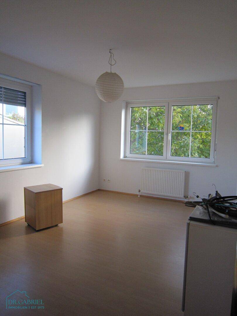 Lichtdurchflutetes Zimmer mit Laminatboden und zwei Fenstern, ideal als Schlafzimmer.