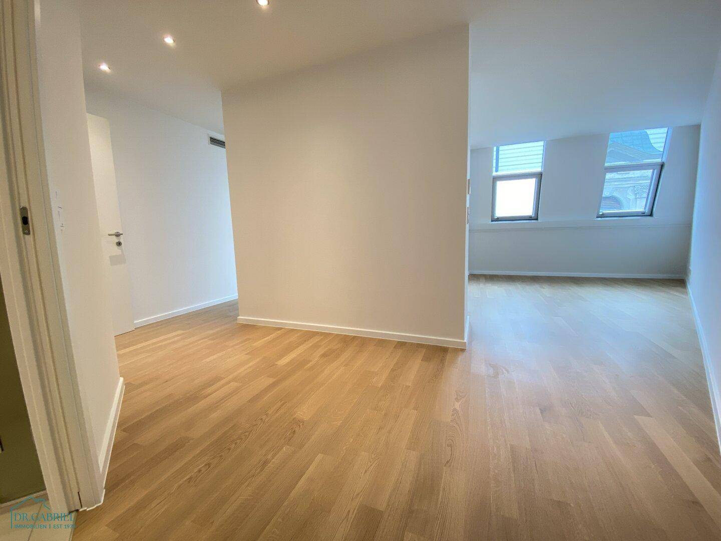 Geräumiger Flur mit Holzboden und Zugang zu verschiedenen Zimmern, ideal für eine offene Wohnraumgestaltung.