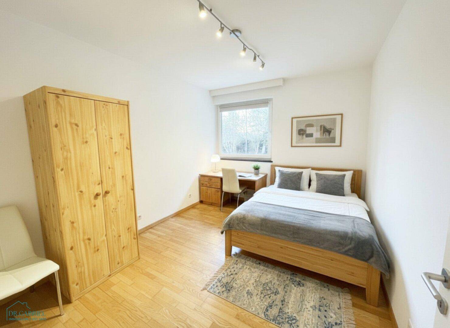 Schlafzimmer mit Einzelbett, Schreibtisch und Holzschrank, ideal als Kinder- oder Gästezimmer.