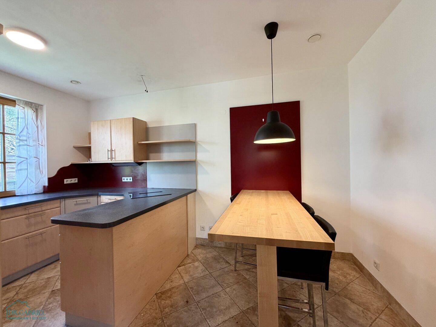 Geräumige Küche mit Essbereich, Holztisch und Fliesenboden, ideal für gemeinsame Mahlzeiten.