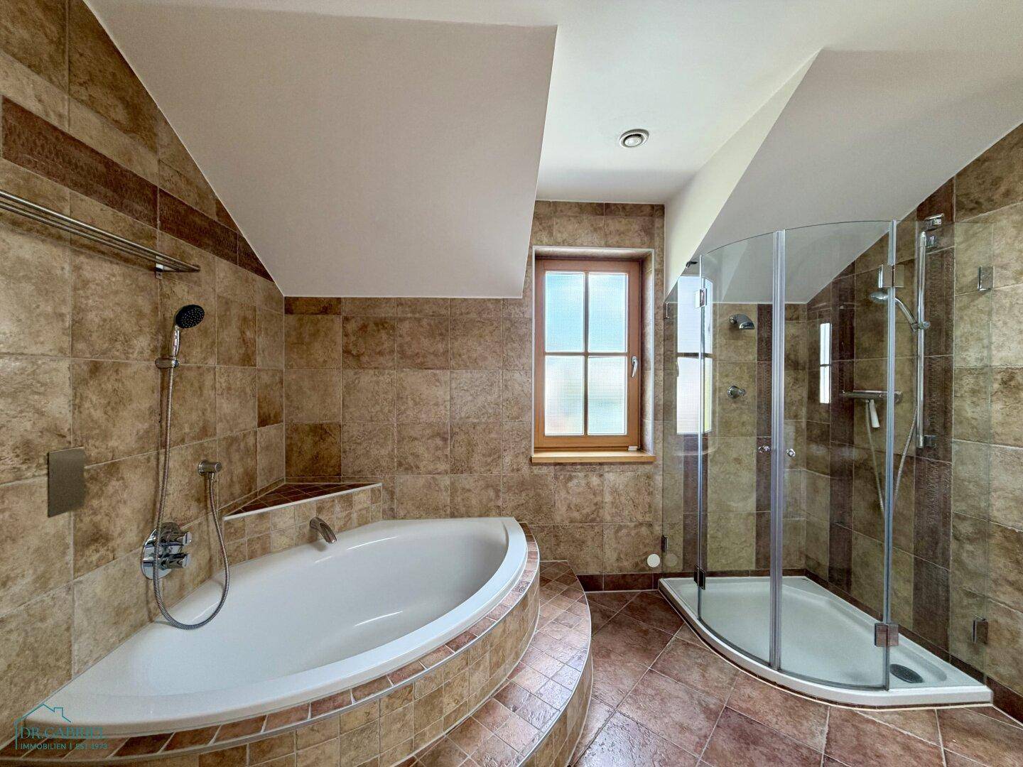 Großes Badezimmer mit Eckbadewanne, Duschkabine und braunen Fliesen, gut gepflegt.