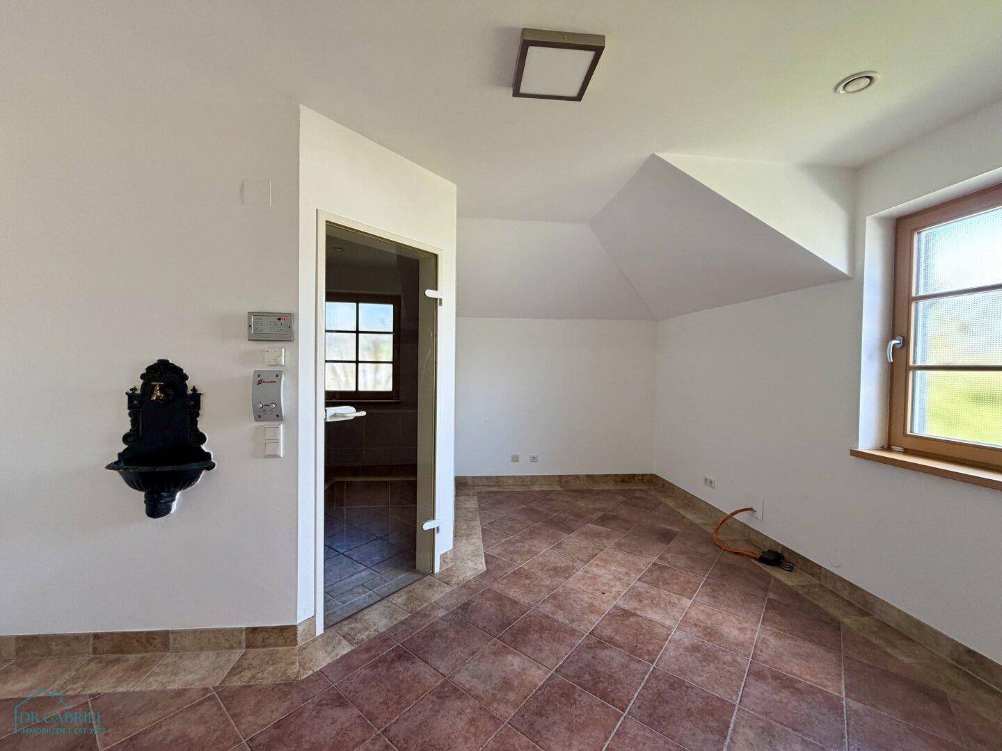 Vielseitiger Raum mit Fliesenboden und Fenster, ideal als Hauswirtschaftsraum oder Vorraum.
