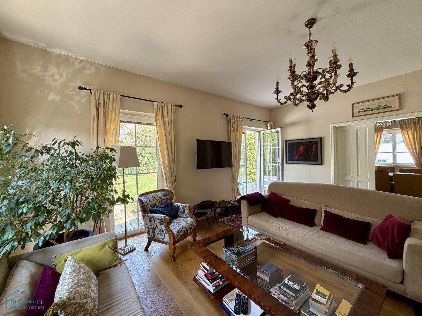 Helles Wohnzimmer mit Holzboden, gemütlichen Sofas und direktem Zugang zum Garten.