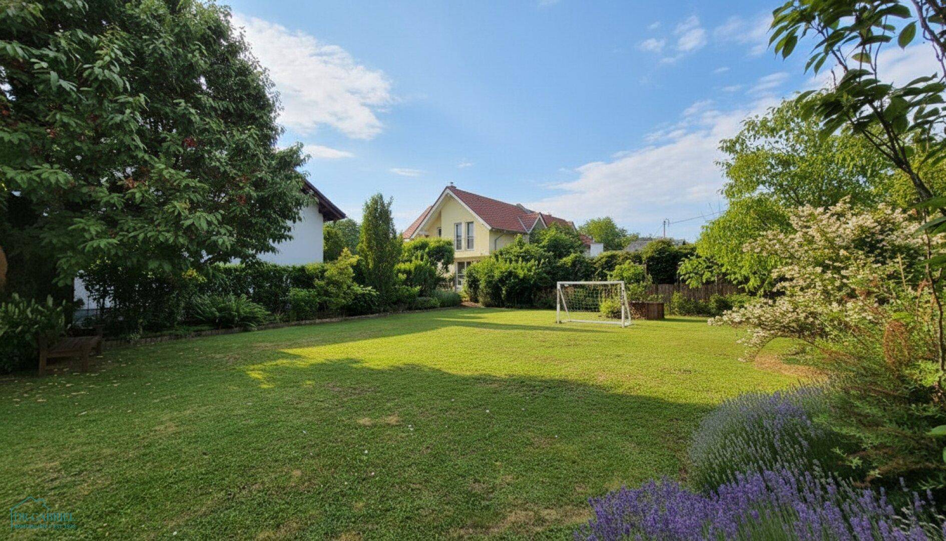 Weitläufiger, gepflegter Garten mit Rasenfläche und Bäumen, ideal für Freizeitaktivitäten.