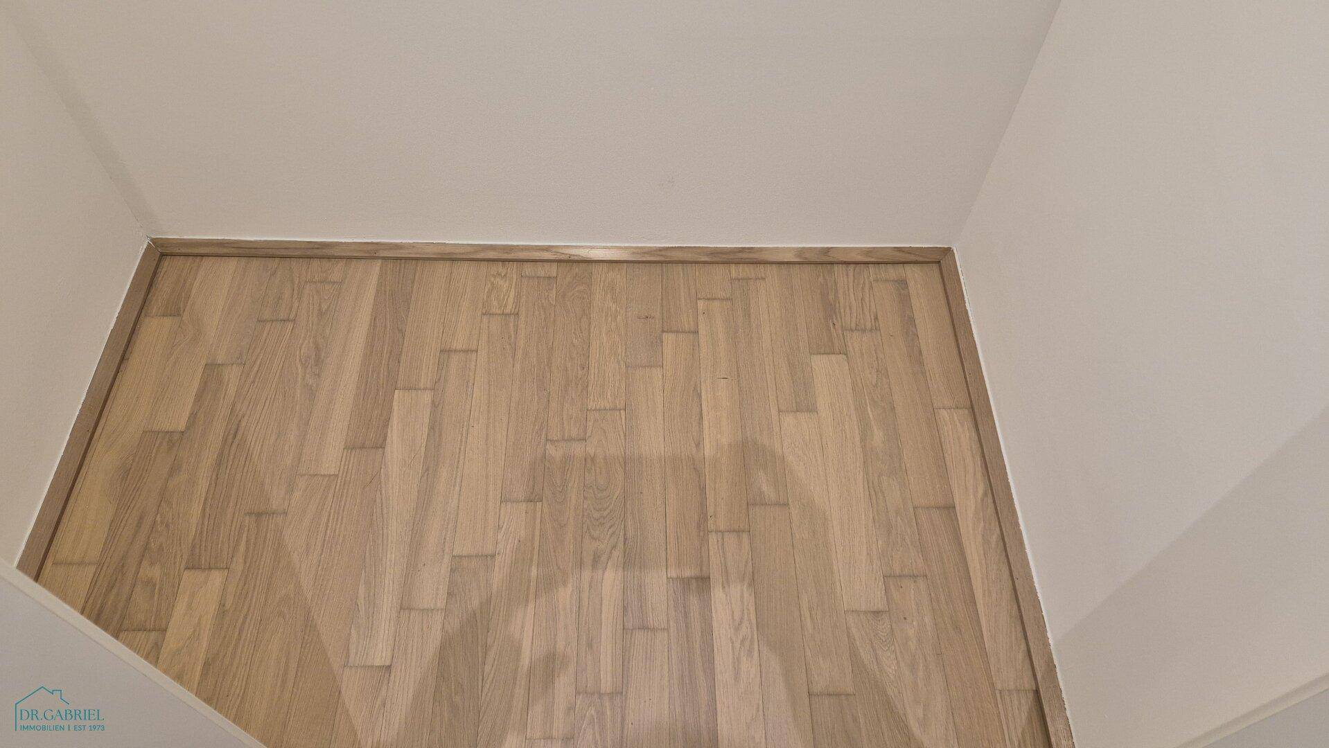 Detailaufnahme eines hochwertigen Parkettbodens in hellem Holzton.