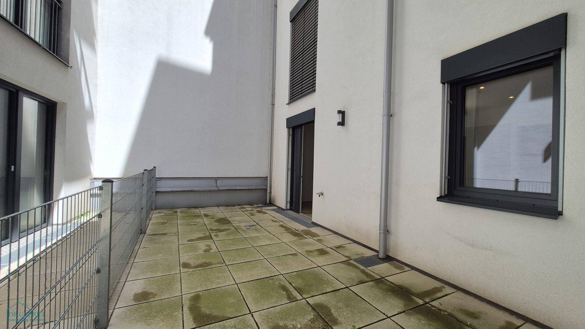 Geräumige, gepflasterte Terrasse im Innenhof, bietet viel Platz für individuelle Gestaltung.