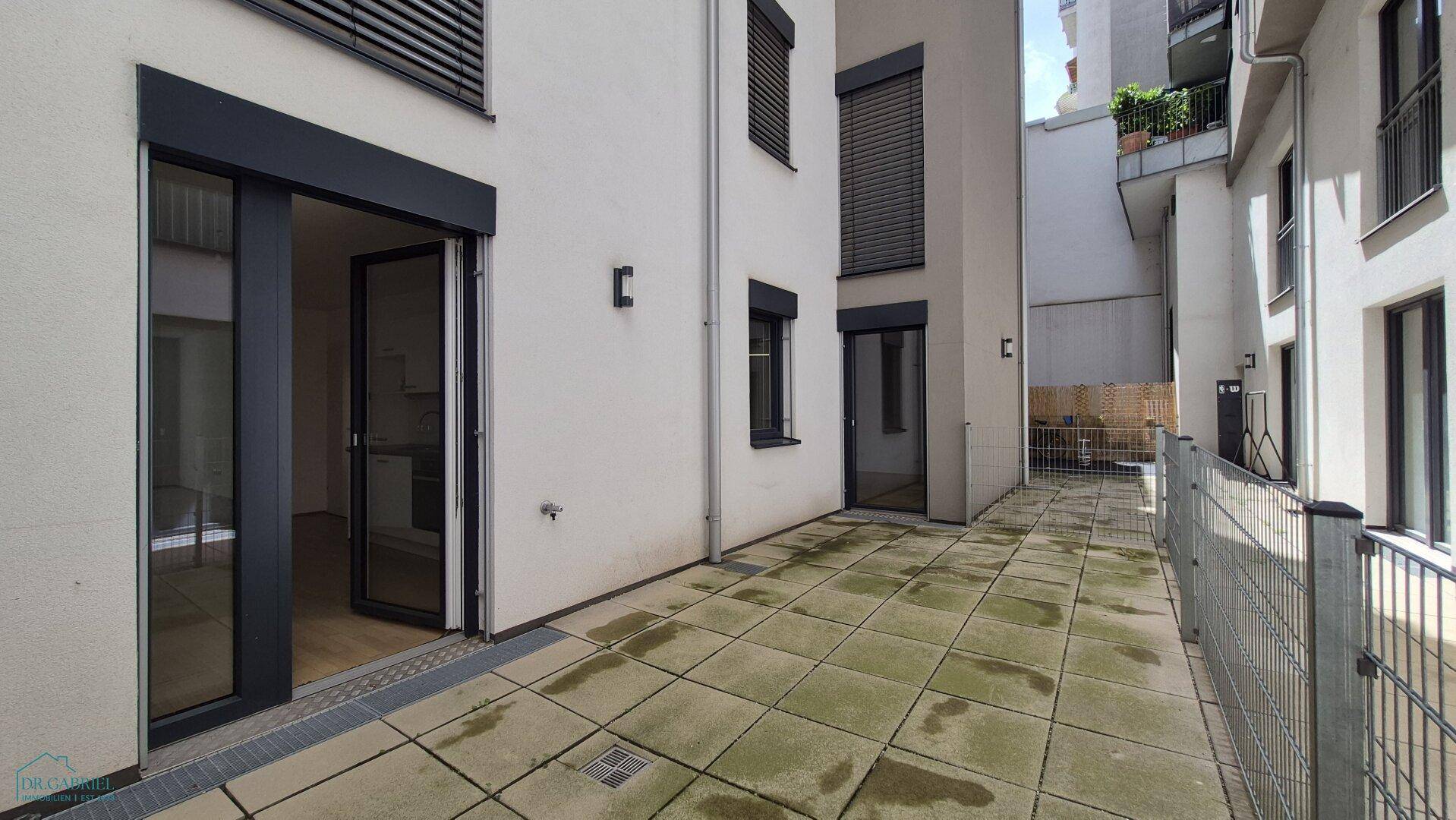 Geräumige, gepflasterte Terrasse im Innenhof, bietet viel Platz für individuelle Gestaltung.
