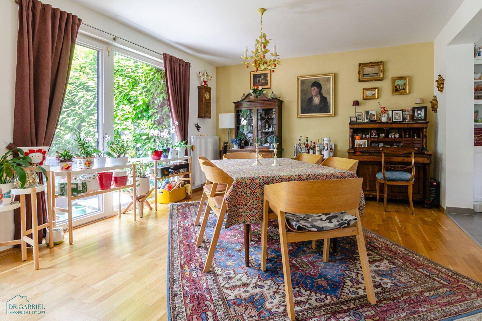 Geräumiges Esszimmer mit großem Holztisch, traditionellen Möbeln und viel Tageslicht.
