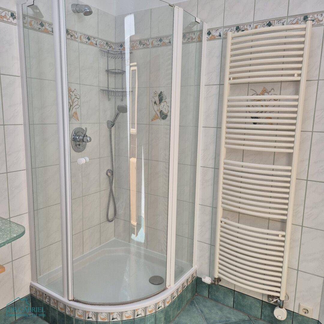 Badezimmer mit Duschkabine und beheiztem Handtuchhalter, um Komfort und Funktionalität zu gewährleisten.