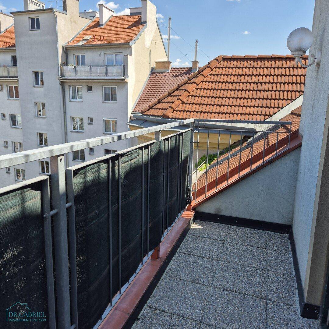 Kleiner Balkon mit Blick auf die umliegenden Dächer und Gebäude, ideal für eine kurze Auszeit.