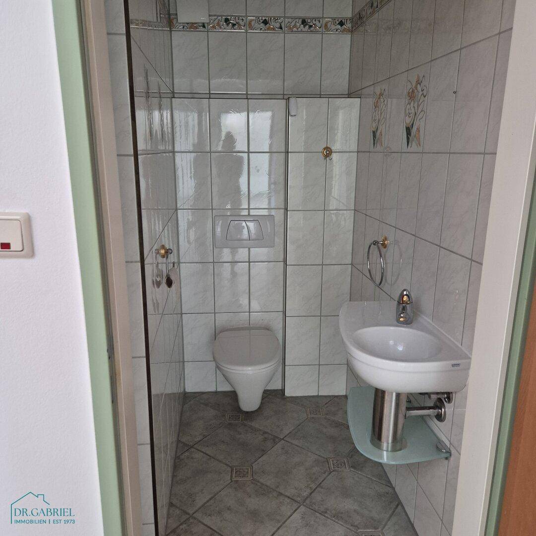 Kleines Gäste-WC mit Toilette und Waschbecken, praktisch und funktional gestaltet.