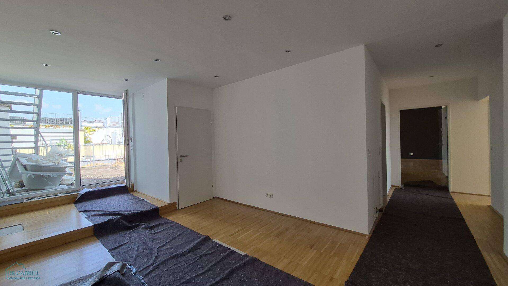Heller Flurbereich mit Parkettboden und Zugang zu einer Außenterrasse.