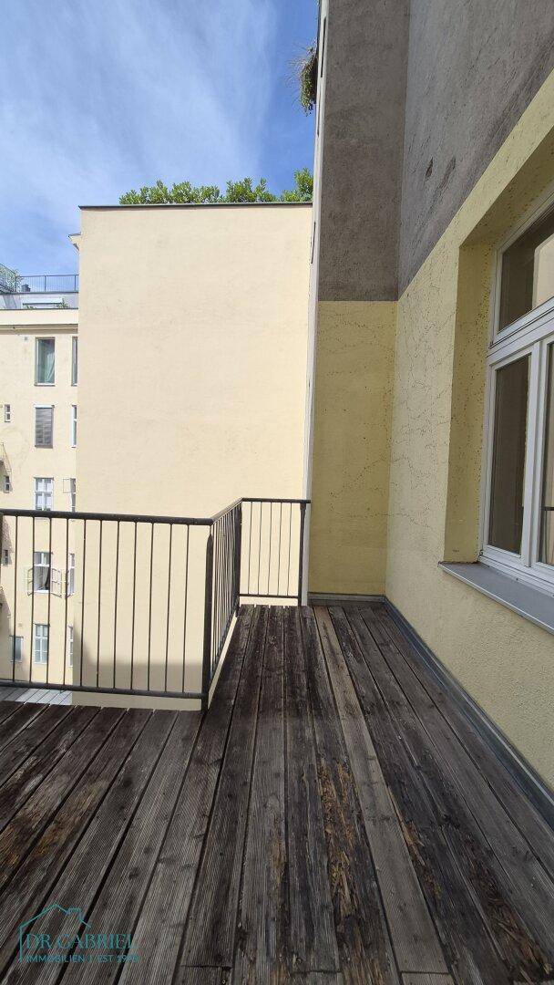 Leerer Balkon mit Holzdielenboden und Metallgeländer, bereit zur individuellen Gestaltung.