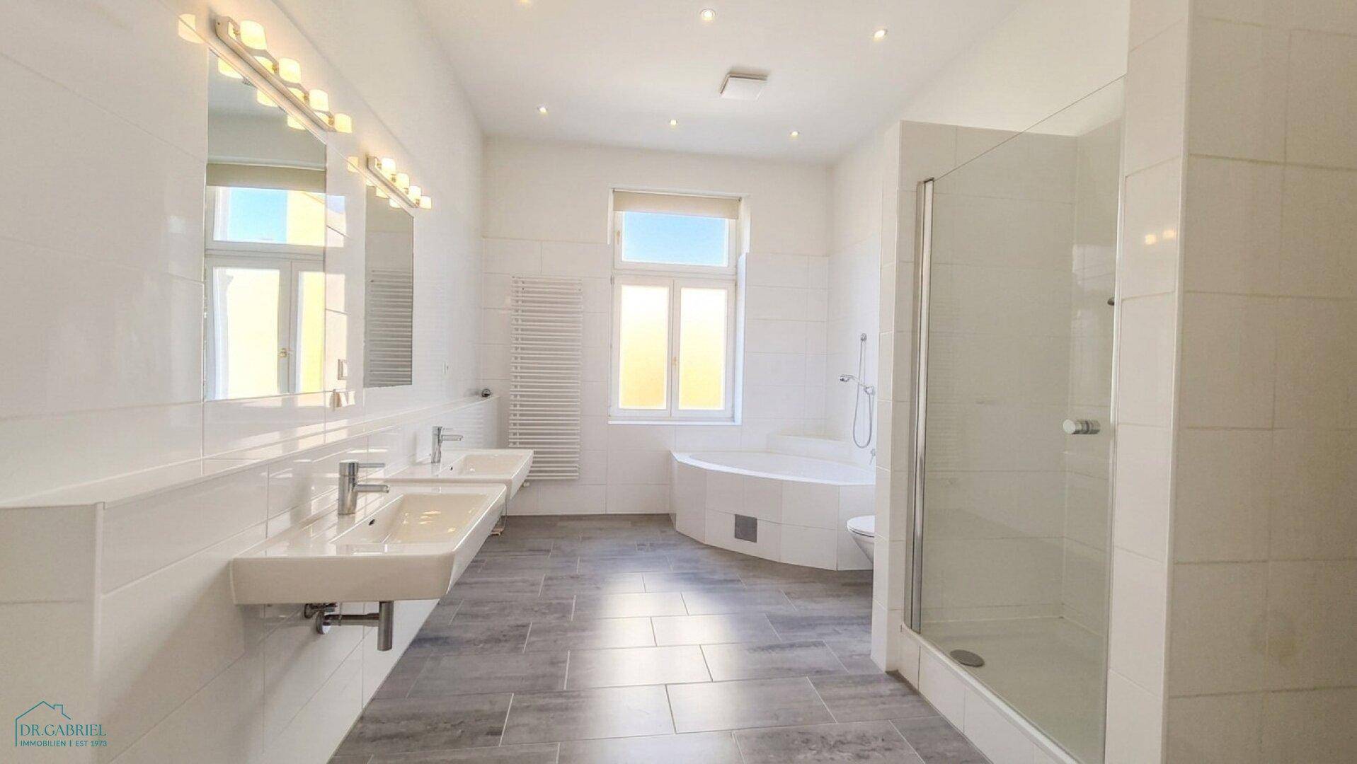 Modernes Badezimmer mit Doppelwaschbecken, großer Dusche und Eckbadewanne.