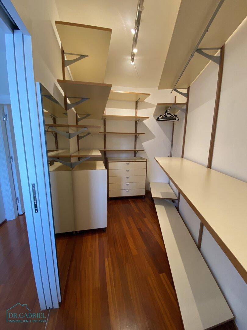 Praktischer begehbarer Kleiderschrank mit Regalen und viel Stauraum.
