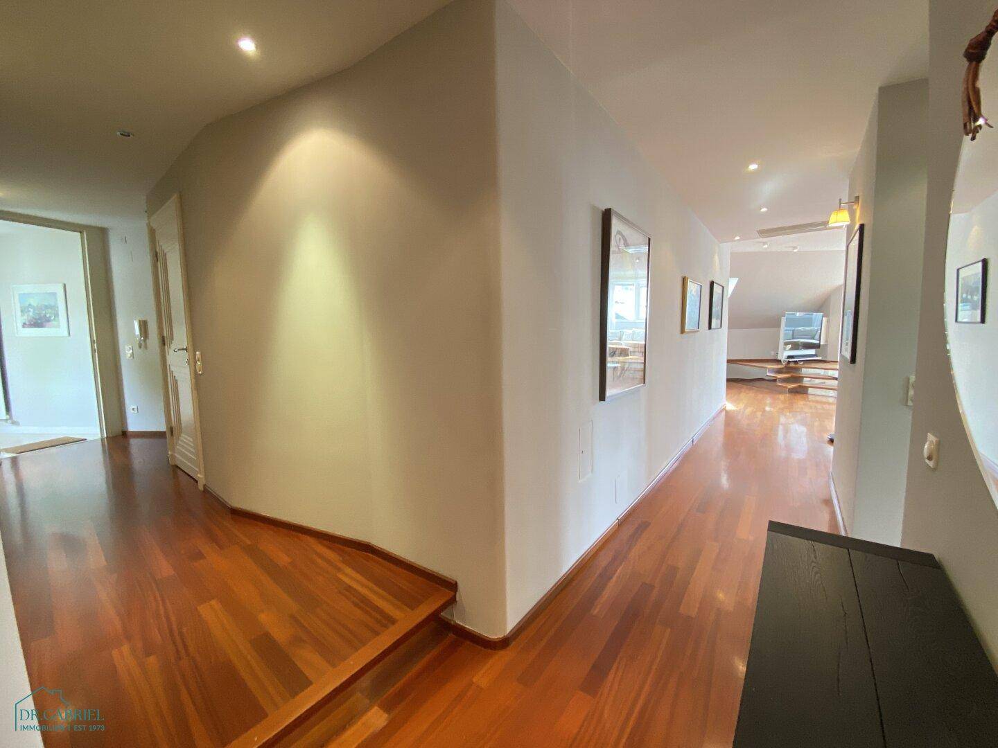 Heller Flur mit Holzboden und Zugang zu verschiedenen Räumen der Wohnung.