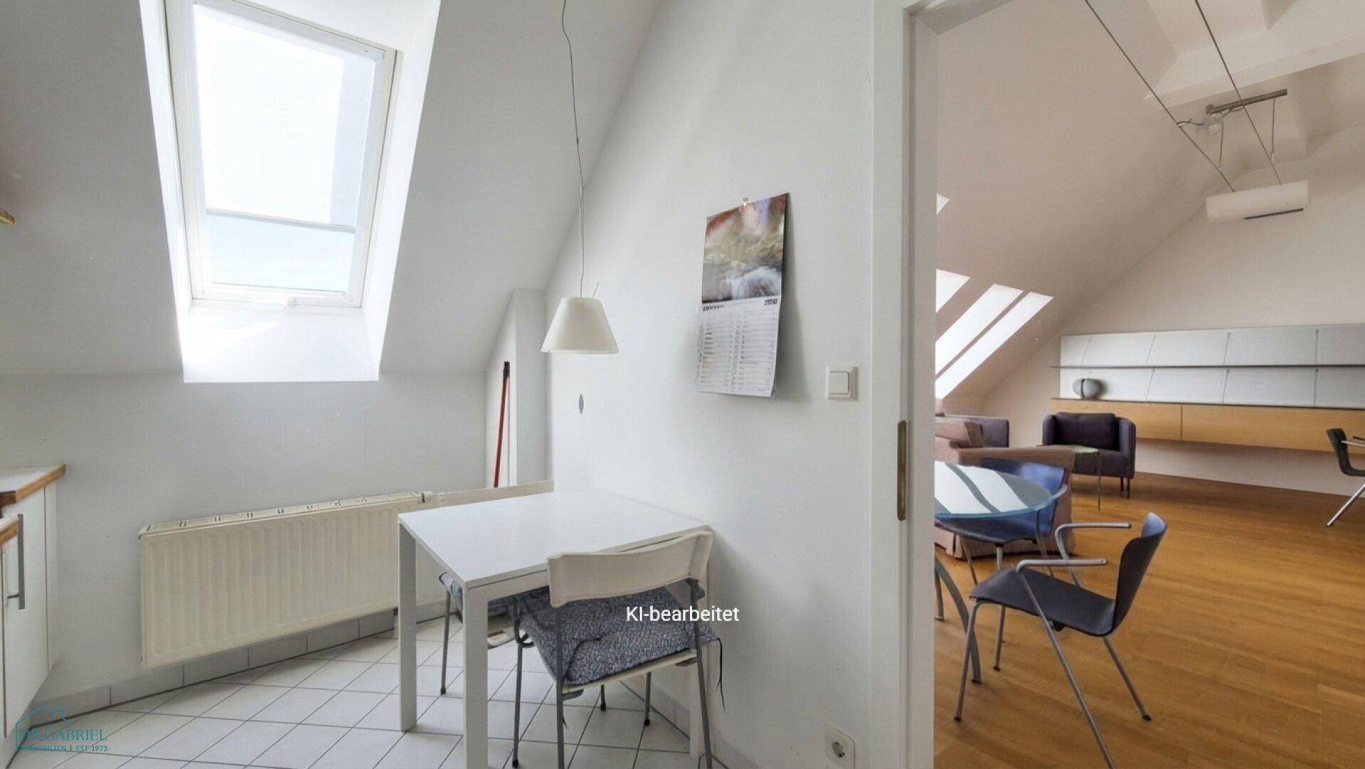 Heller Essbereich in der Küche mit Dachfenster und Blick in den Wohnbereich.
