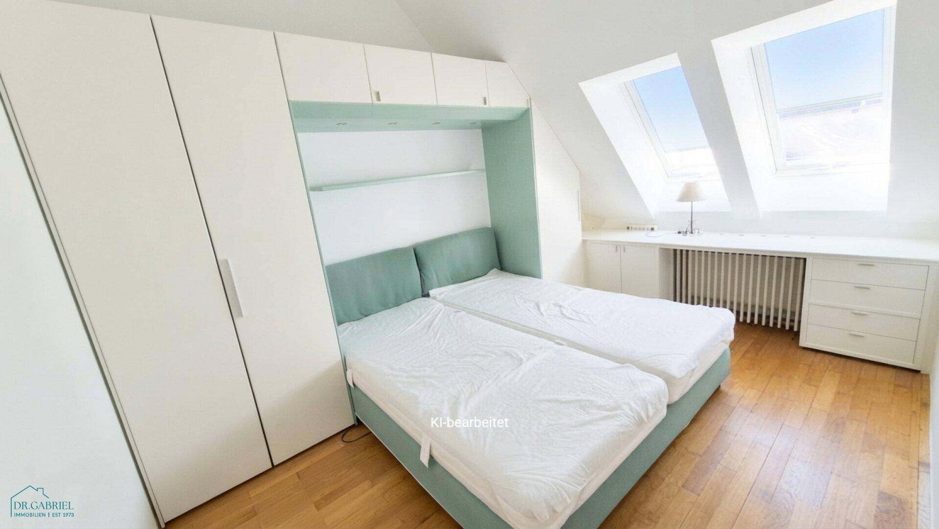 Schlafzimmer im Dachgeschoss mit zwei Einzelbetten, Einbauschränken und Dachfenstern.