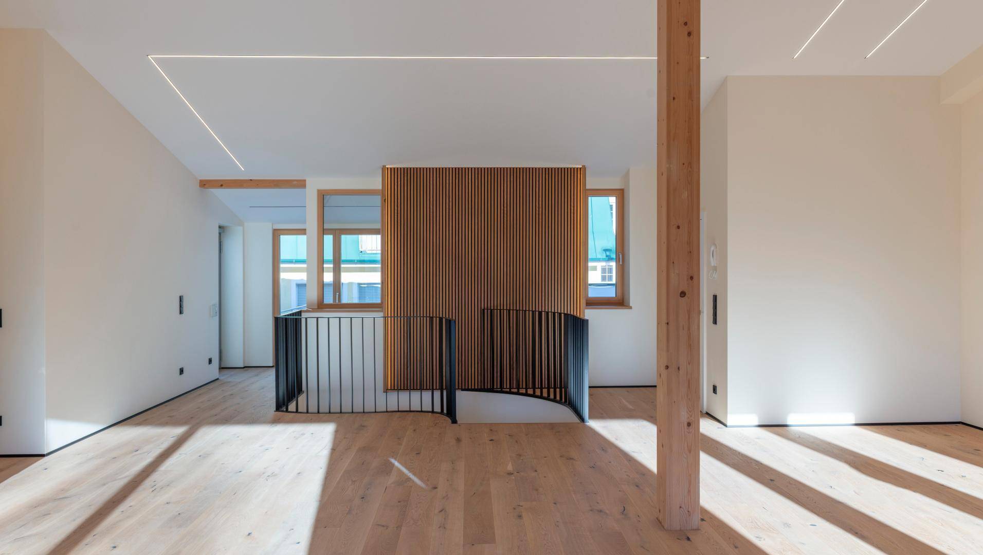 Heller Flurbereich mit Holzfußboden, moderner Treppe und dekorativer Holzvertäfelung.