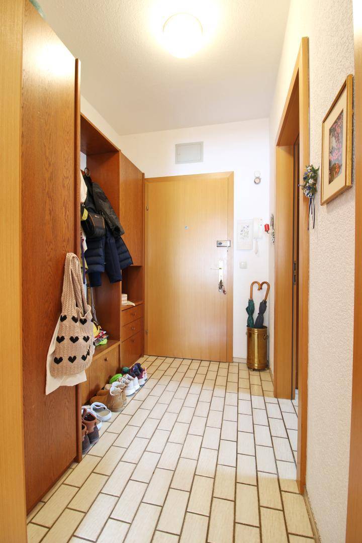 Eingangsbereich mit Fliesenboden, Einbauschränken und Garderobe für zusätzlichen Stauraum.