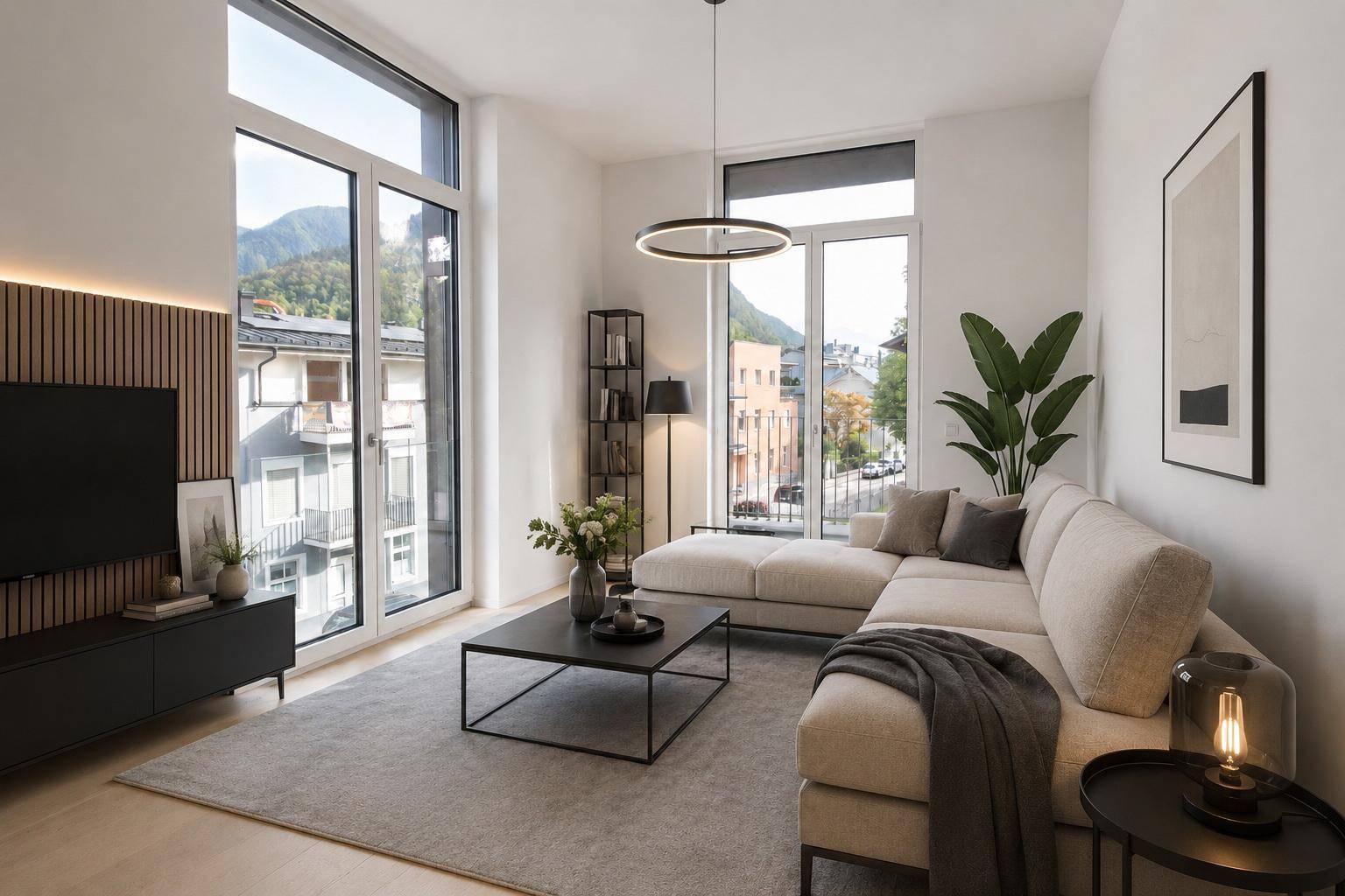 Helles Wohnzimmer mit beigem Ecksofa, großen Fenstern und Blick auf die Umgebung.