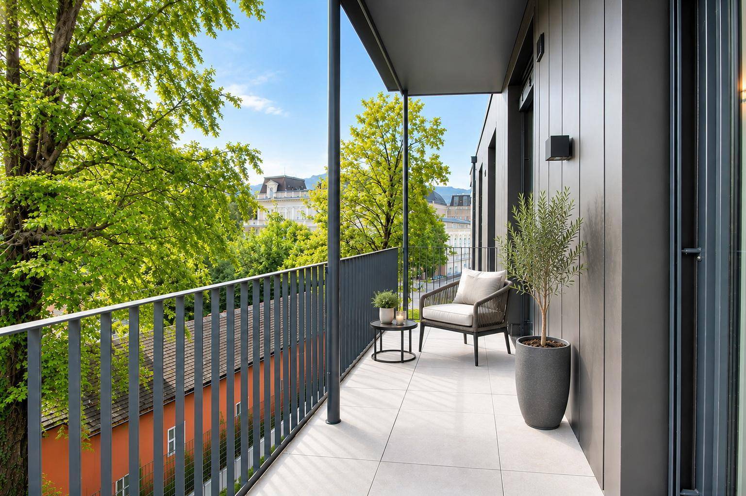 Geräumiger Balkon mit Fliesenboden, Sitzgelegenheit und üppigem Grünblick.