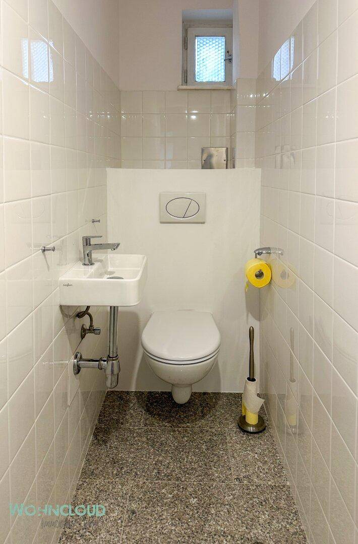 Kleines, modernes Gäste-WC mit wandhängendem WC, Waschbecken und Fenster.