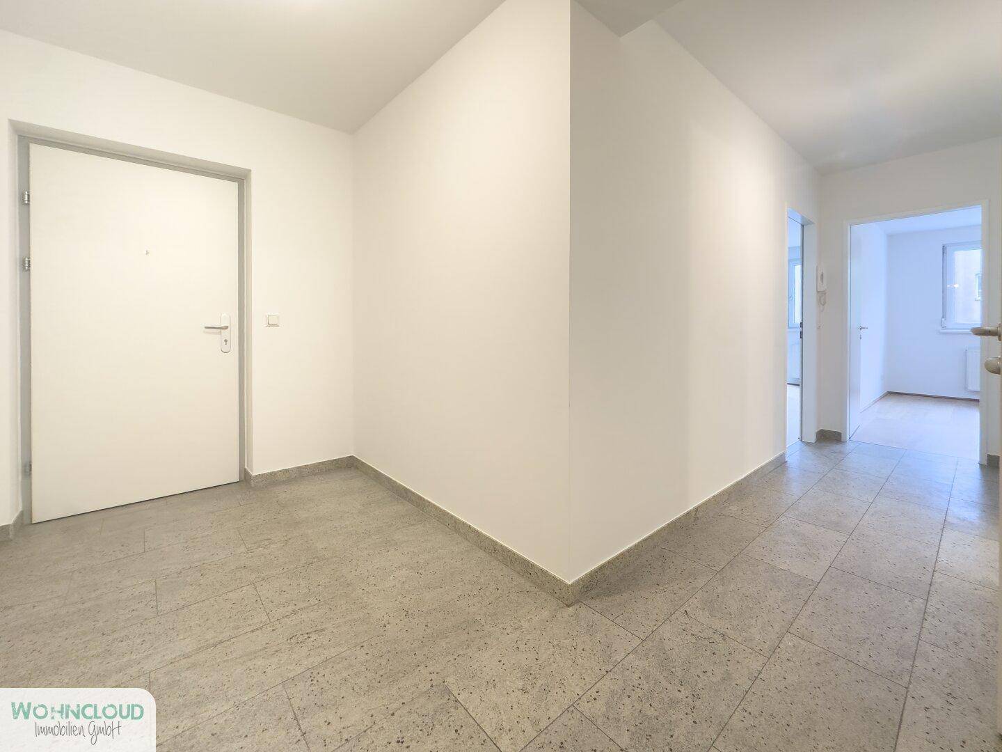 Heller Eingangsbereich mit Fliesenboden und Zugang zu weiteren Räumen der Wohnung.