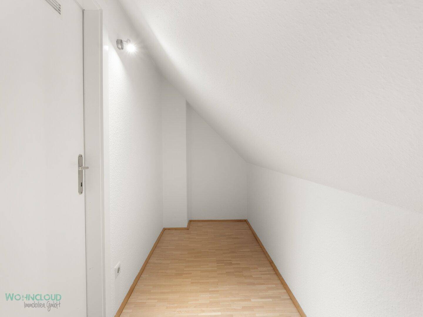 Kleiner Abstellraum mit Schrägdach und hellem Parkettboden, ideal für zusätzlichen Stauraum.