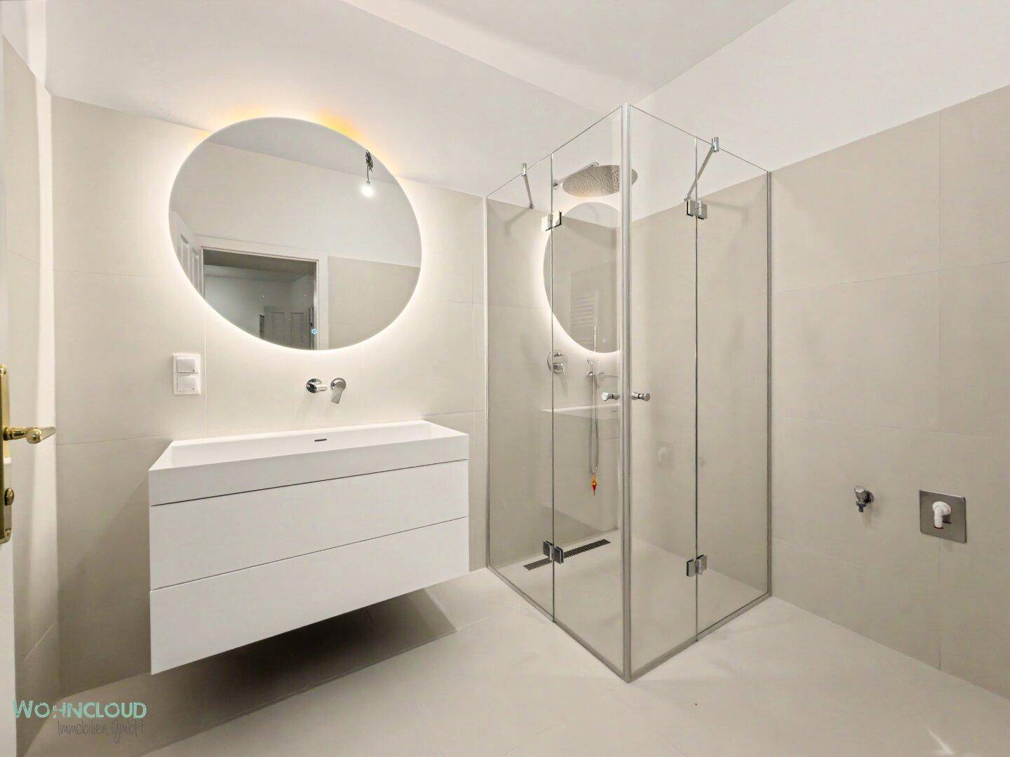 Modernes Badezimmer mit begehbarer Dusche, schwebendem Waschtisch und beleuchtetem Spiegel.