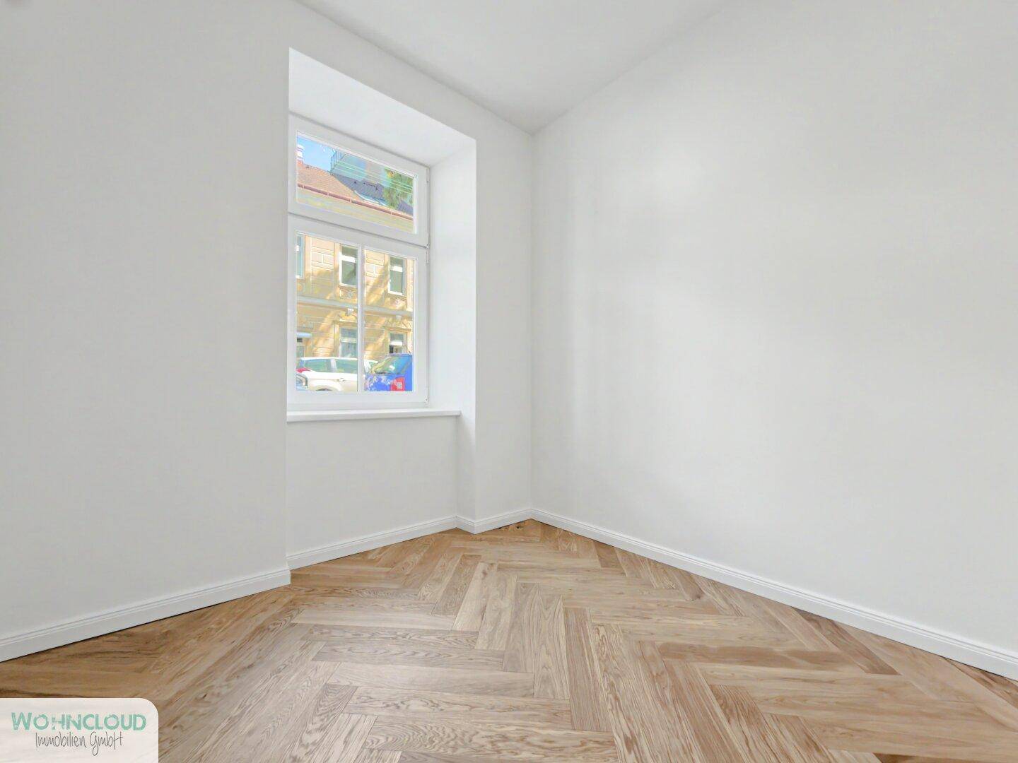 Kleines, helles Zimmer mit Fischgrätparkett und Fenster, ideal als Kinderzimmer oder Büro.