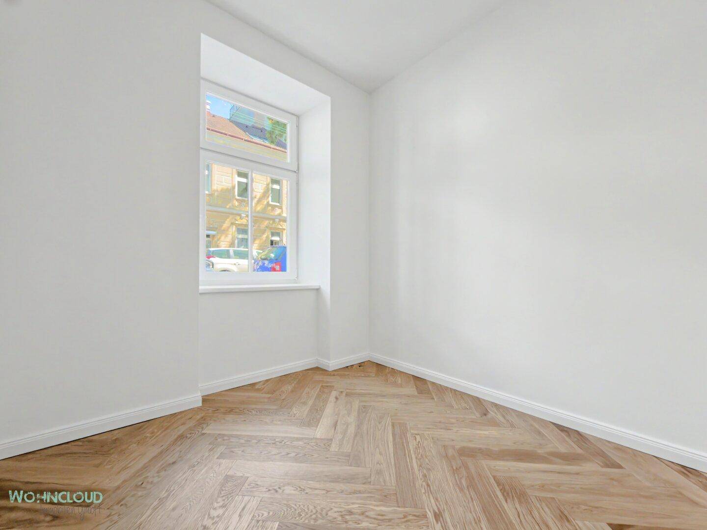 Kleines, helles Zimmer mit Fischgrätparkett und Fenster, ideal als Kinder- oder Arbeitszimmer.