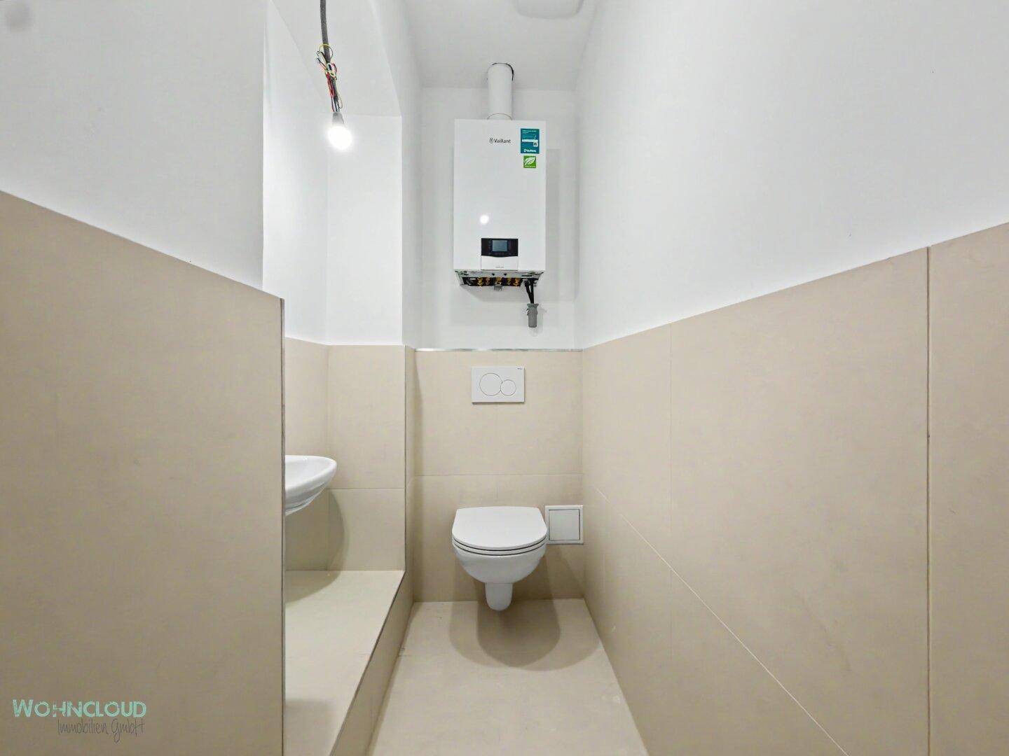 Kleines, modernes Gäste-WC mit Wand-WC, Waschbecken und Gastherme.