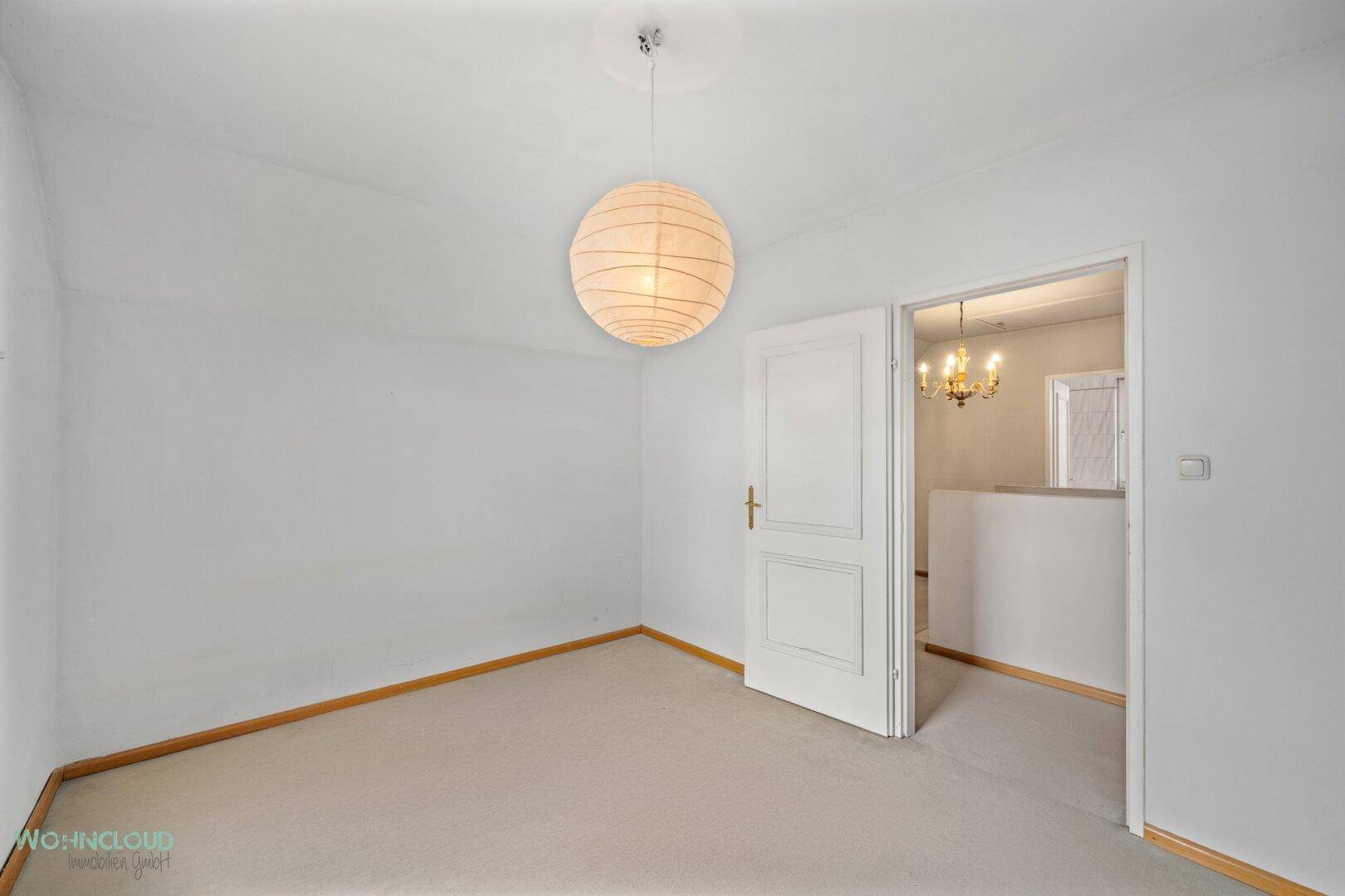 Schlafzimmer mit Teppichboden und einer modernen Deckenleuchte, bereit zur individuellen Gestaltung.