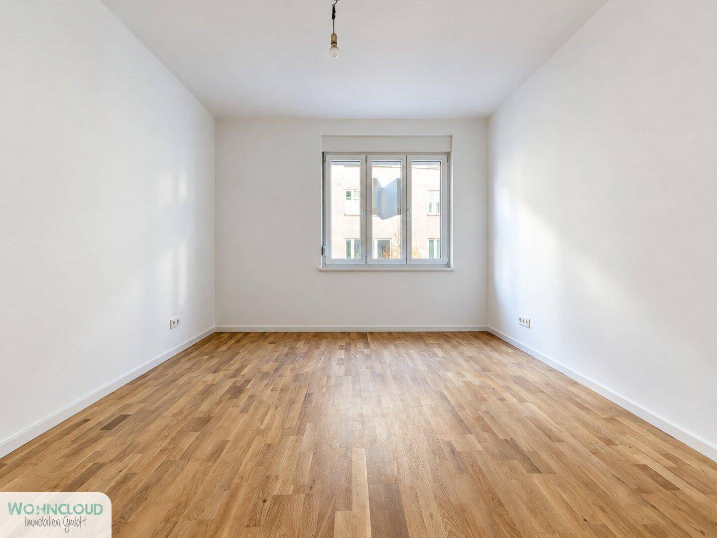 Geräumiger, heller Raum mit Parkettboden und großen Fenstern, bereit zur Einrichtung.