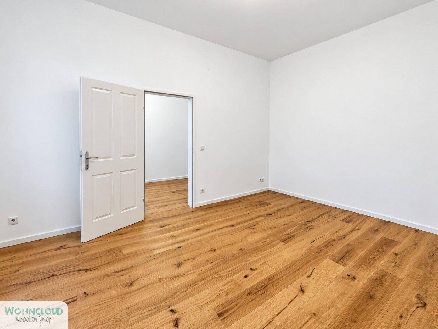 Geräumiges Zimmer mit hellem Holzboden und weißen Wänden, ideal für vielfältige Nutzung.
