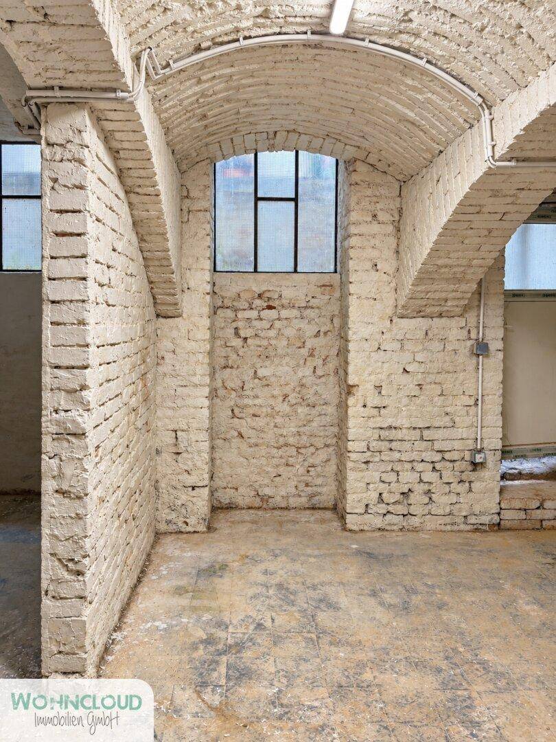Historischer Kellerraum mit Ziegelwänden, gewölbten Decken und einem Fenster für Belüftung.