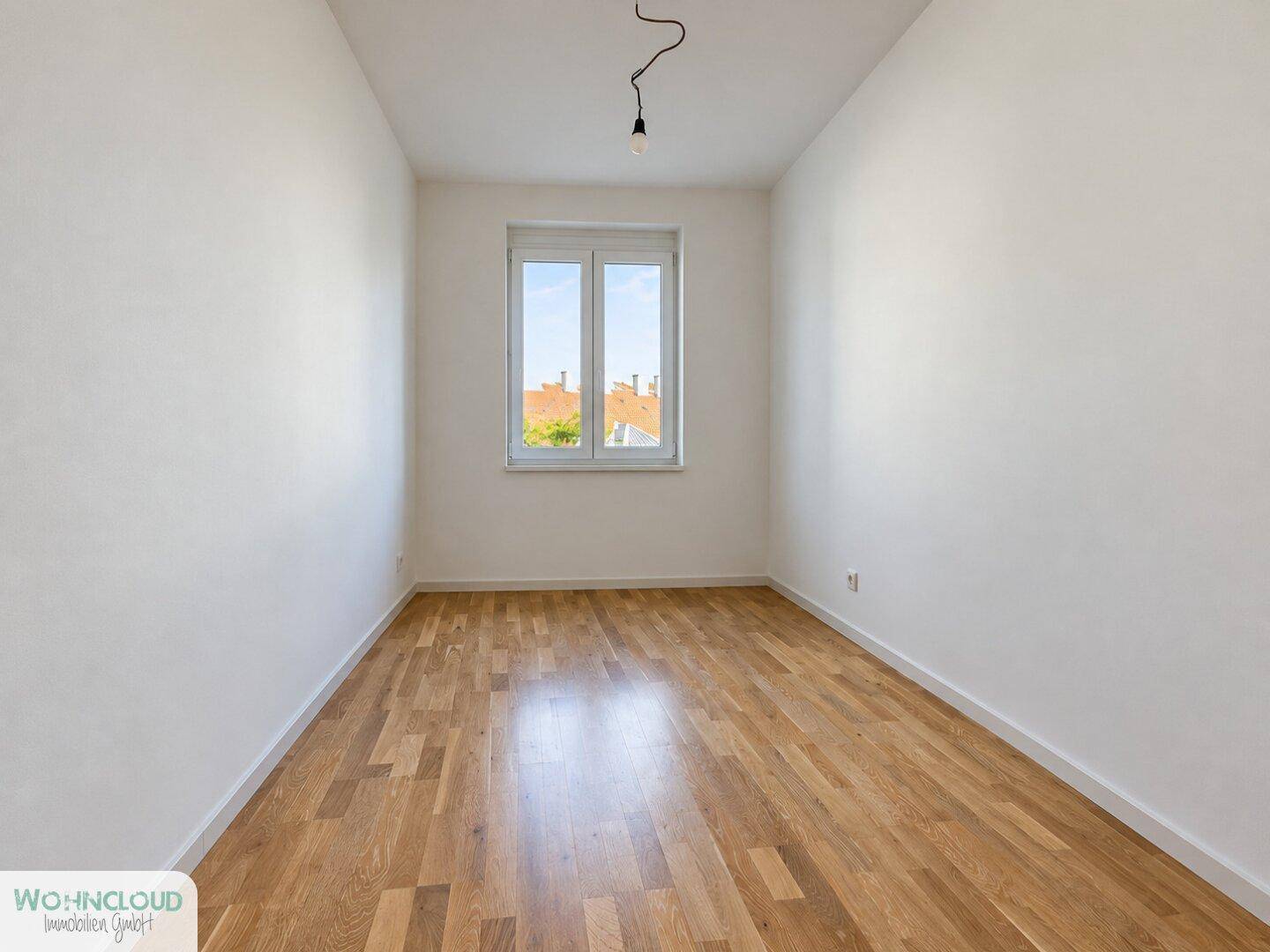 Kleineres, helles Zimmer mit Holzboden und Fenster, ideal als Schlaf- oder Arbeitszimmer.