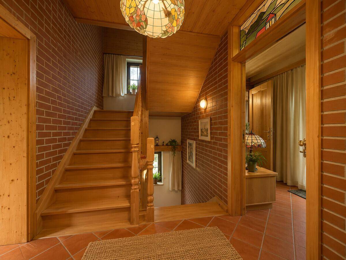 Treppenhaus mit Holzstufen, Ziegelwänden und dekorativer Tiffany-Lampe.