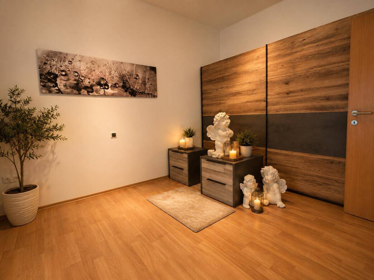 Schlafzimmer mit Holzboden, Nachttischen und großem Kleiderschrank.
