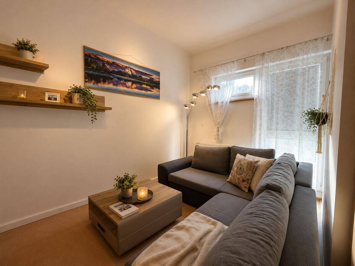 Gemütliches Wohnzimmer mit Ecksofa, Couchtisch und dekorativen Elementen.