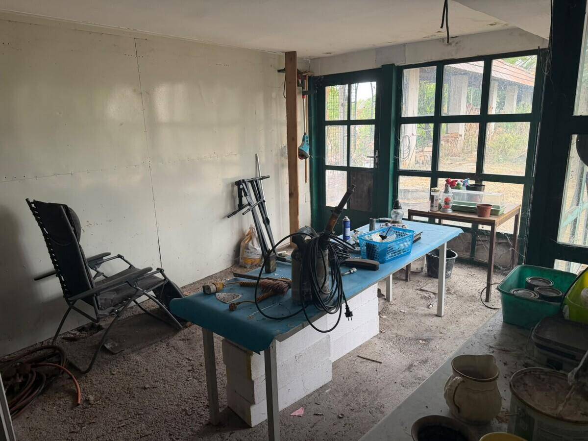 Einfacher Werkstattraum mit großen Fenstern und Blick ins Freie.
