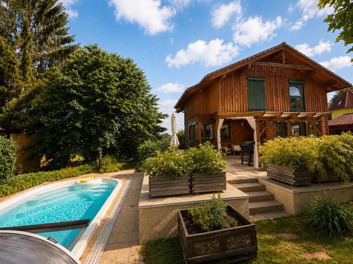 Großzügiger Außenbereich mit Pool, Terrasse und dem einladenden Holzhaus.