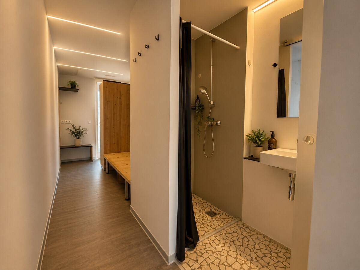 Heller Flur mit Zugang zu einem Schlafzimmer und einem Badezimmer mit Duschbereich.