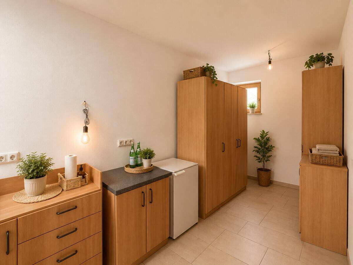 Vielseitiger Raum mit Schränken, kleiner Küchenzeile und Fenster.