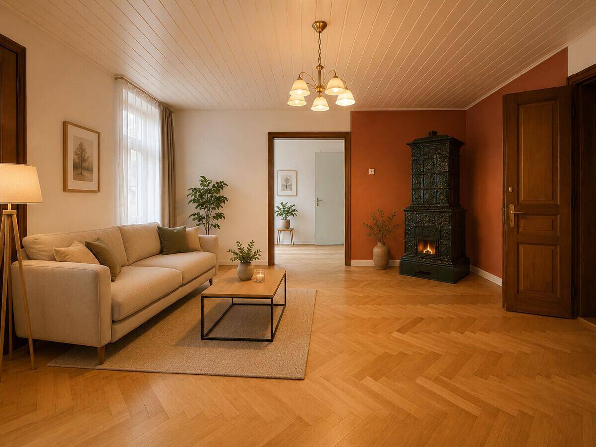 Gemütliches Wohnzimmer mit Sofa, Couchtisch und traditionellem Kachelofen.