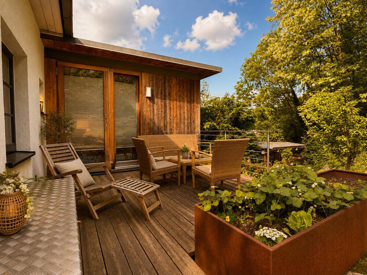 Gemütliche Holzterrasse mit Sitzgelegenheiten und Blick auf die umliegende Natur.