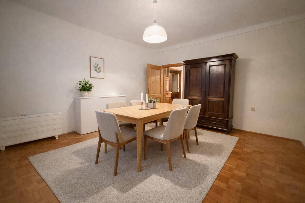 Heller Essbereich mit modernem Holztisch, bequemen Stühlen und einem großen dunklen Schrank.